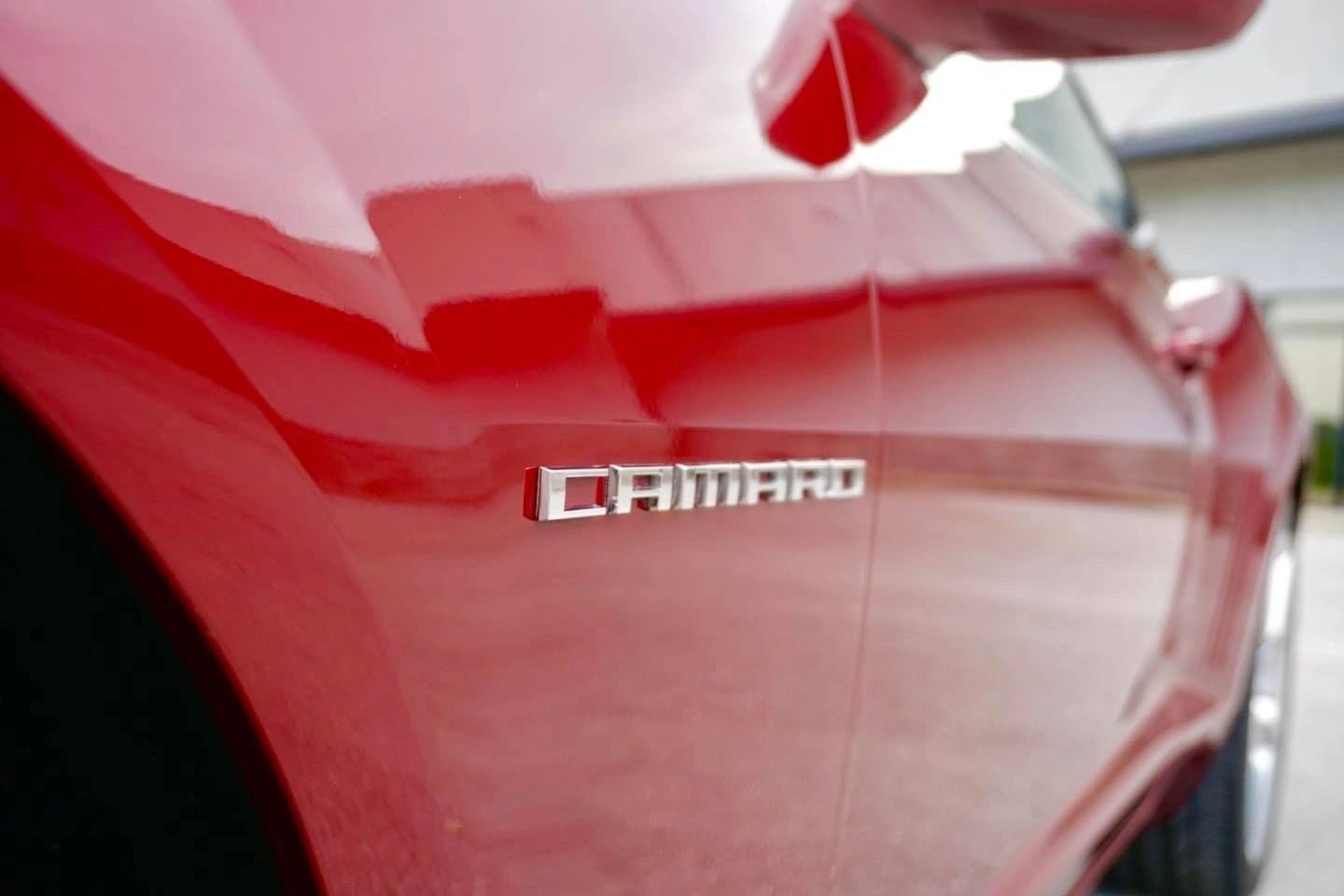A red Camaro with a high-gloss ceramic coated finish